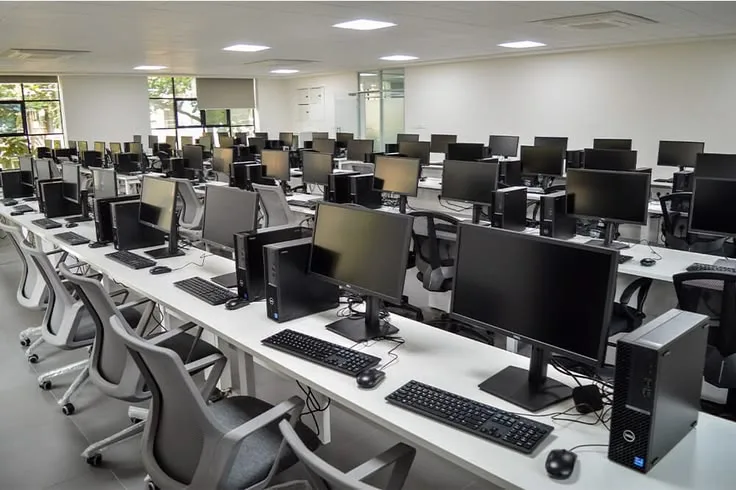 Salle informatique équipée, postes alignés pour une session d'examen